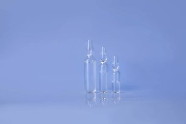 Ampul ile sıvı enjeksiyon için RAW. Ara-cam ampul ile tıp sıvı mavi zemin üzerine mühür.