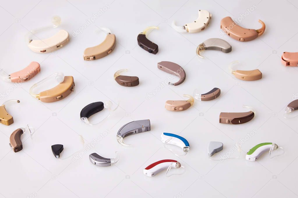 Various hearing aids on white background, alternative to surgery. ENT accessory