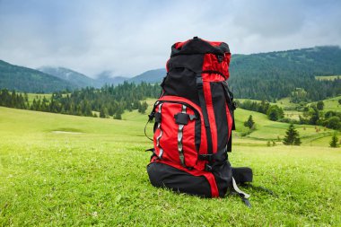 Dağ manzara görünümü arka plan üzerinde seyahat sırt çantası. Gezgin öğeleri. Tatil. Seyahat Aksesuarları. Tatil. Uzun hafta sonu gün kapalı. İn seyahat