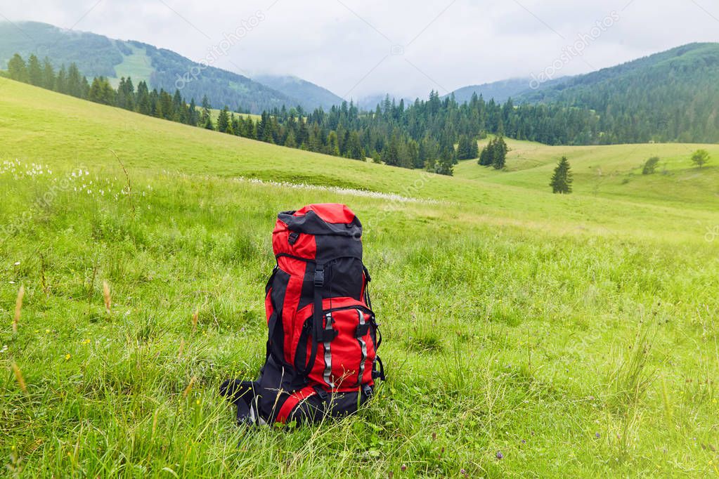 Travel backpack on the mountain  landscape view background. Traveler items. Vacation. Travel accessories. Holiday. Long weekend Day off. Travelling stuff