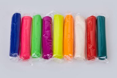 Beyaz bir arka plan üzerinde izole renkli hamuru kümesi. Hamuru oynamak kil şeffaf paket içinde modelleme hamur