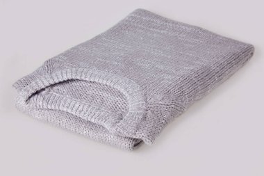 Gri, beyaz arka plan üzerinde boş etiketi ile örme kazak katlanmış. Giyim, moda kavramı. Uzun kollu tunik