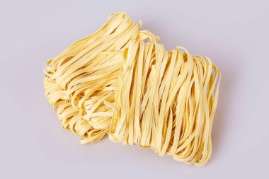 Kuru kalın erişte kare şekli haddelenmiş. Capelli d'angelo, Angel'ın saç - makarna. Ev yapımı makarna çeşitleri tagliatelle. İtalyan mutfağı. Yumurta noodle. Beyaz arka plan üzerinde izole