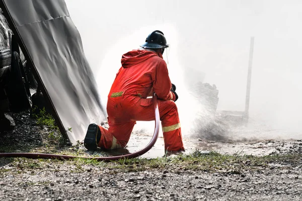 Bir yangın söndürmek için adam sprey su ateş