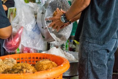 Bir işçi olarak yerel bir pazarda daha fazla tüketim için hindistancevizi hazırlanıyor