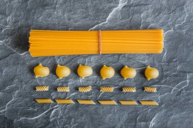 Taş zeminde farklı türde makarna. İtalyan yemeği.