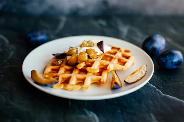 Lezzetli Viyana Waffle 'ları tabakta. Ekşi kremalı waffle, bal ve meyveli.