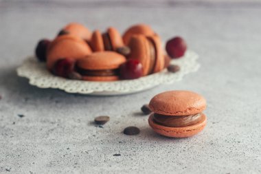 Kurabiyeler. Lezzetli Fransız tatlıları. Makarnalar masaya. Çikolatalı ve kirazlı kurabiye.