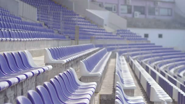 小男孩足球运动员的慢动作与足球跑在体育场的看台之间 — 图库视频影像