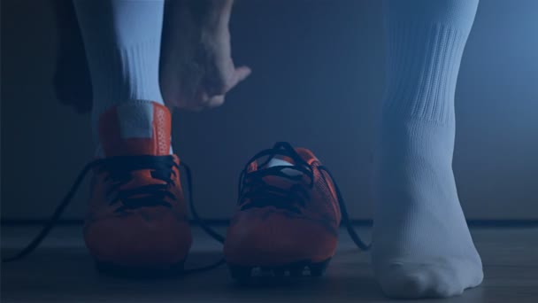 サッカーのフットボール選手が彼の靴を履きます スローモーション — ストック動画