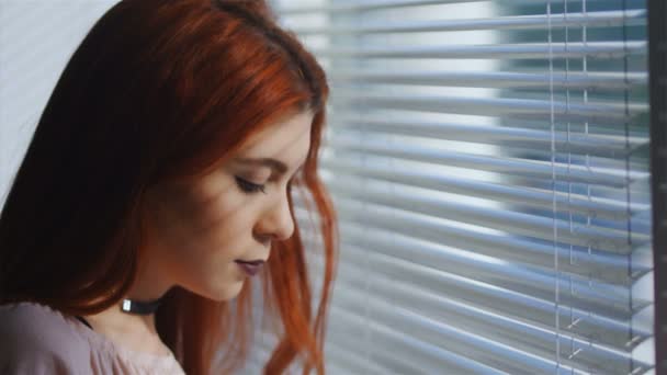 Hermosa Joven Mirando Hacia Ventana Través Las Persianas Hasta Calle — Vídeos de Stock