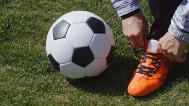 Futbol, futbol maçı. Profesyonel futbolcu antrenmandan önce kırmızı ayakkabılarını takar, 4K
