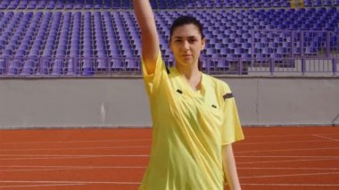 Asistan kadın hakem bir futbol maçı sırasında kenarda hareket ediyor.