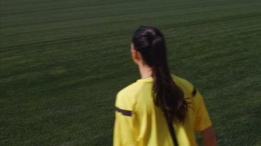 Asistan kadın hakem bir futbol maçı sırasında kenarda hareket ediyor.