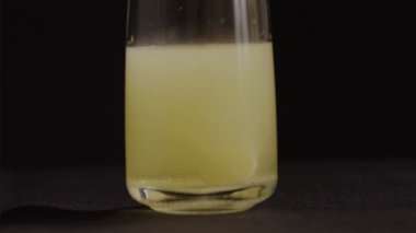 Siyah arka planda bir bardak suda C vitamini kabarcıkları, 4K