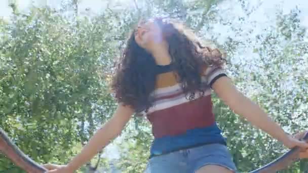 一个快乐的年轻女子的画像 一头美丽的卷曲的秀发在旋转木马上 四千块 — 图库视频影像