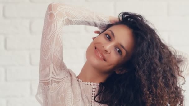 Retrato Una Hermosa Joven Con Pelo Rizado Una Pared Blanca — Vídeo de stock