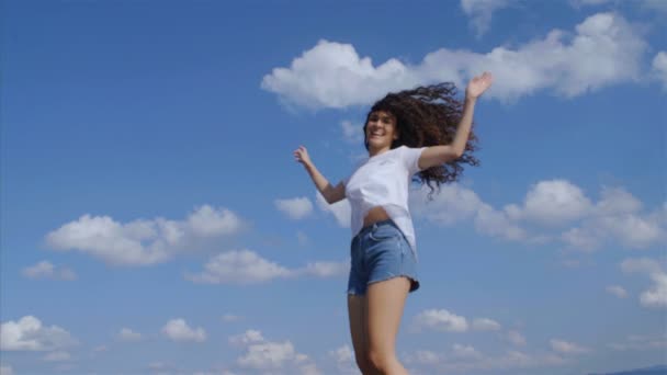 Jovem Feliz Com Belo Cabelo Encaracolado Pulando Fundo Céu Azul — Vídeo de Stock