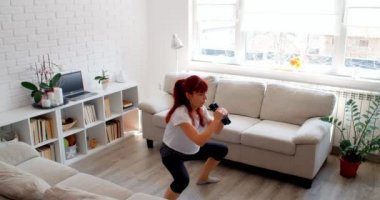 COVID-19 kavramı. Karantina sırasında evde tek başına spor yapan bir kadın. 4k