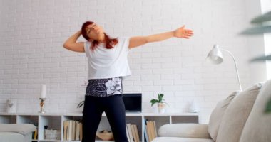 COVID-19 kavramı. Karantina sırasında evde tek başına spor yapan bir kadın. 4k