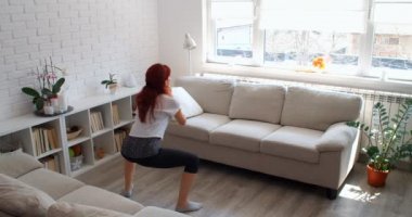 COVID-19 kavramı. Karantina sırasında evde tek başına spor yapan bir kadın. 4k