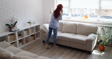 COVID-19 kavramı. Karantina sırasında evde yalnız başına akıllı telefondan konuşan bir kadın. 4k