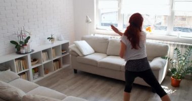 COVID-19 kavramı. Karantina sırasında evde tek başına spor yapan bir kadın. 4k