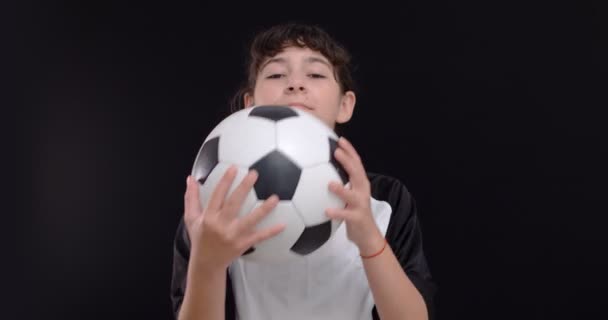 Portrét dospívající dívky fotbalista s fotbalovým míčem na černém pozadí, 4k