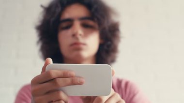 4K Genç çocuk akıllı telefonunda kayıyor, düşük açı, pov