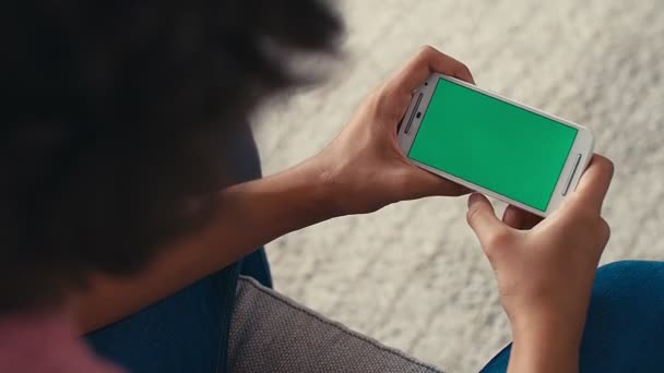4Kティーンエイジャーの少年は 緑の画面で彼の携帯電話で何かを見ている間に肯定的な反応を表現 — ストック動画