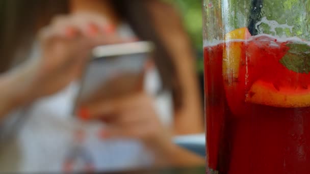 Mädchen Trinken Limonade Und Benutzen Ein Smartphone — Stockvideo