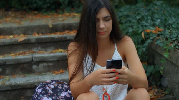 Πορτρέτο Μιας Όμορφης Νεαρής Γυναίκας Που Χρησιμοποιεί Smartphone Στο Πάρκο — Αρχείο Βίντεο