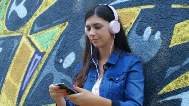 Ragazza Abbastanza Caucasica Ascoltare Musica Con Cuffie Smartphone Outdoor Parete — Video Stock