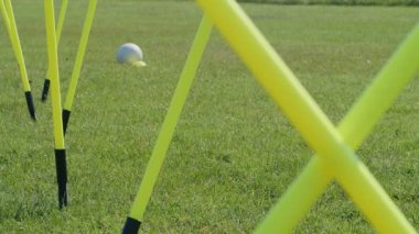 Futbol çeviklik eğitim ekipmanları. Çeviklik çubukları olan genç bir futbolcunun bacaklarının detaylı görüntüsü. 4k