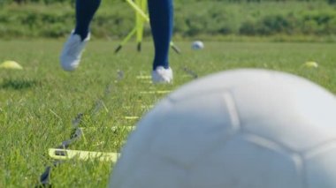 Futbolcu genç bir kadının çeviklik merdiveni ile bacaklarının detaylı çekimi. 4k