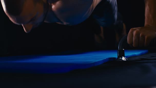 ハンサムな強いボディビルダー運動選手は黒の背景のボディービルの概念で床の上でプッシュワークアウトを行います — ストック動画