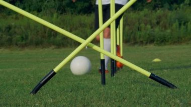 Sahada futbol topuyla antrenman yapan bir oyuncunun ayakları, 4K ağır çekim.