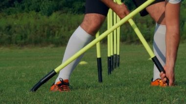 Futbolcu antrenman için direkleri sahaya koyuyor, 4k ağır çekim.