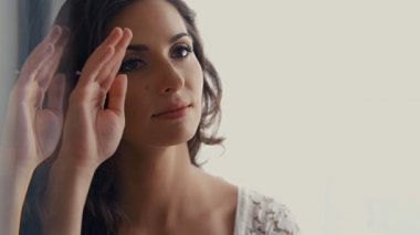 Genç bir kadın aynanın karşısında oturmuş kendine hayran hayran hayran hayran, saçlar, 4k ağır çekim.