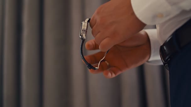 エレガントな男実業家の新郎は 結婚式の時計を固定するつもりだ 4Kスローモーション — ストック動画