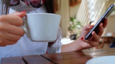 Güzel ve başarılı bir iş kadını, laptopuyla kafede kahve içiyor, dizüstü bilgisayarda çalışıyor ve telefon kullanıyor, detaylar, 4K