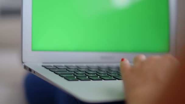 年轻女子坐在家里的沙发上 用绿色屏幕的笔记本电脑 — 图库视频影像