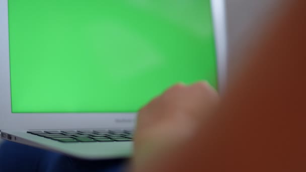 年轻女子坐在家里的沙发上 用绿色屏幕的笔记本电脑 — 图库视频影像