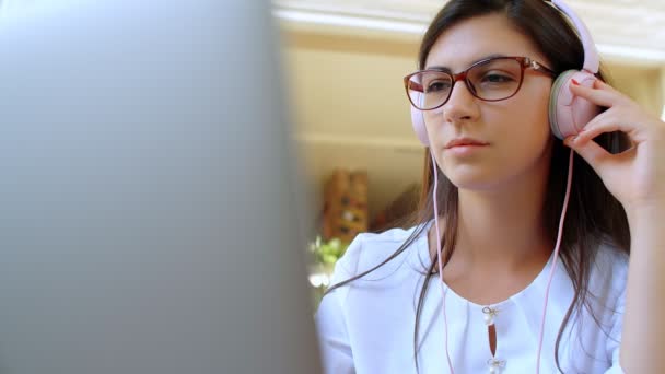 Kulaklıklı Cafe Dizüstü Bilgisayarla Çalışan Başarılı Genç Güzel Bir Kadını — Stok video