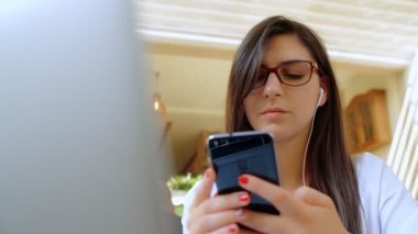 Laptopta Çalışan ve Akıllı Telefon Kullanan Güzel Genç İş Kadını Kafe, Pov, 4k ağır çekimde