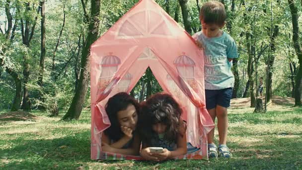 Twee Meisjes Spelen Met Een Smartphone Het Park Liggend Tent — Stockvideo