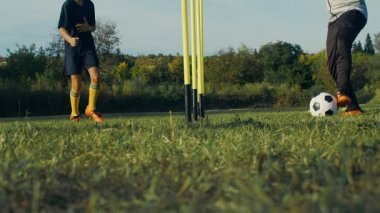 Çocuk futbolcu koçuyla sahada antrenman yapıyor, 4K ağır çekimde.