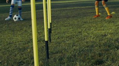 Çocuk futbolcu koçuyla sahada antrenman yapıyor, 4K ağır çekimde.