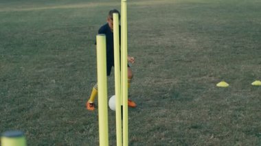 Çocuk futbol topuyla sahada antrenman yapıyor, 4 km ağır çekimde.