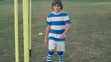 Çocuk futbolcu sahada kutlama jesti yapıyor, 4K ağır çekim.